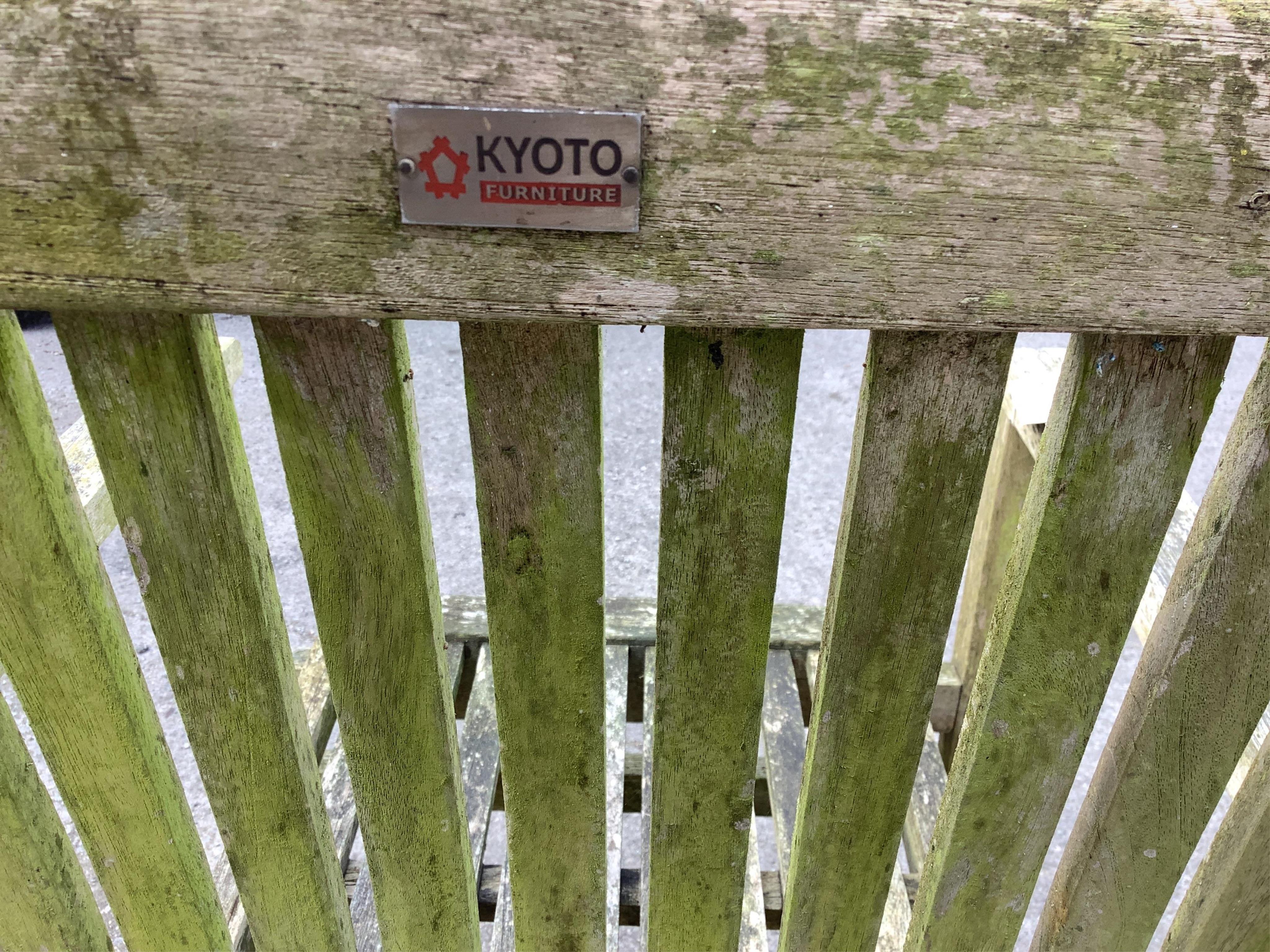 A “Kyoto” weathered teak extending garden table, width 240cm extended, depth 100cm, height 75cm, together with six stacking elbow chairs. Condition - fair